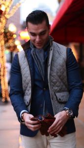 Men's Fall Jacket Trends, men's gray quilted vest worn over blue blazer with scarf