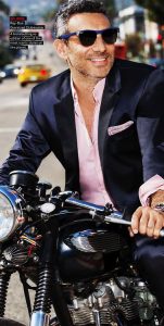 men's navy suit with pink button down shirt unbuttoned and cuffed on a motorcycle