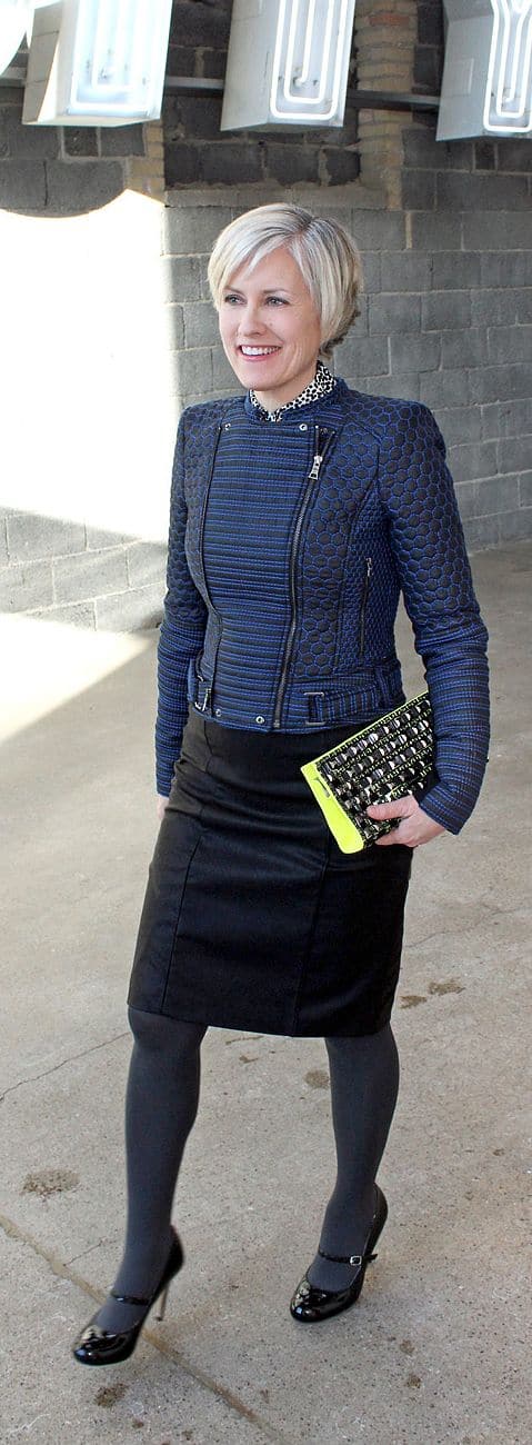 50 and stylish modern looks wearing leather, blue leather texture bomber jacket with black leather skirt