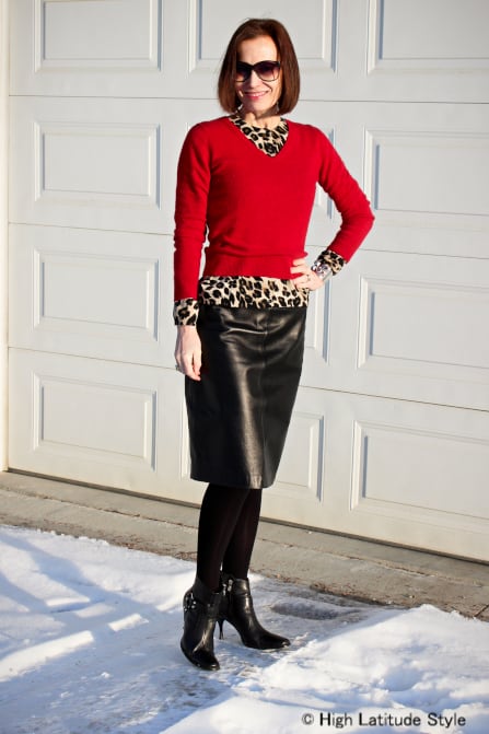 50 and stylish work to evening chic outfit leather skirt animal print top red sweater and shoe booties Divine Style