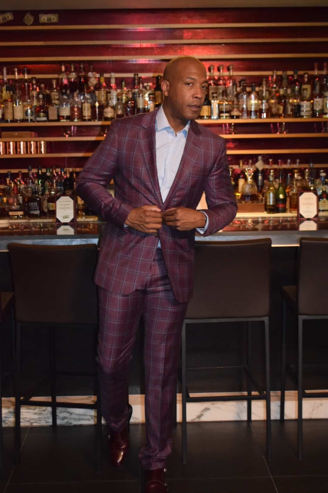 Barnette Holston wearing plaid wine color suit and striped button down