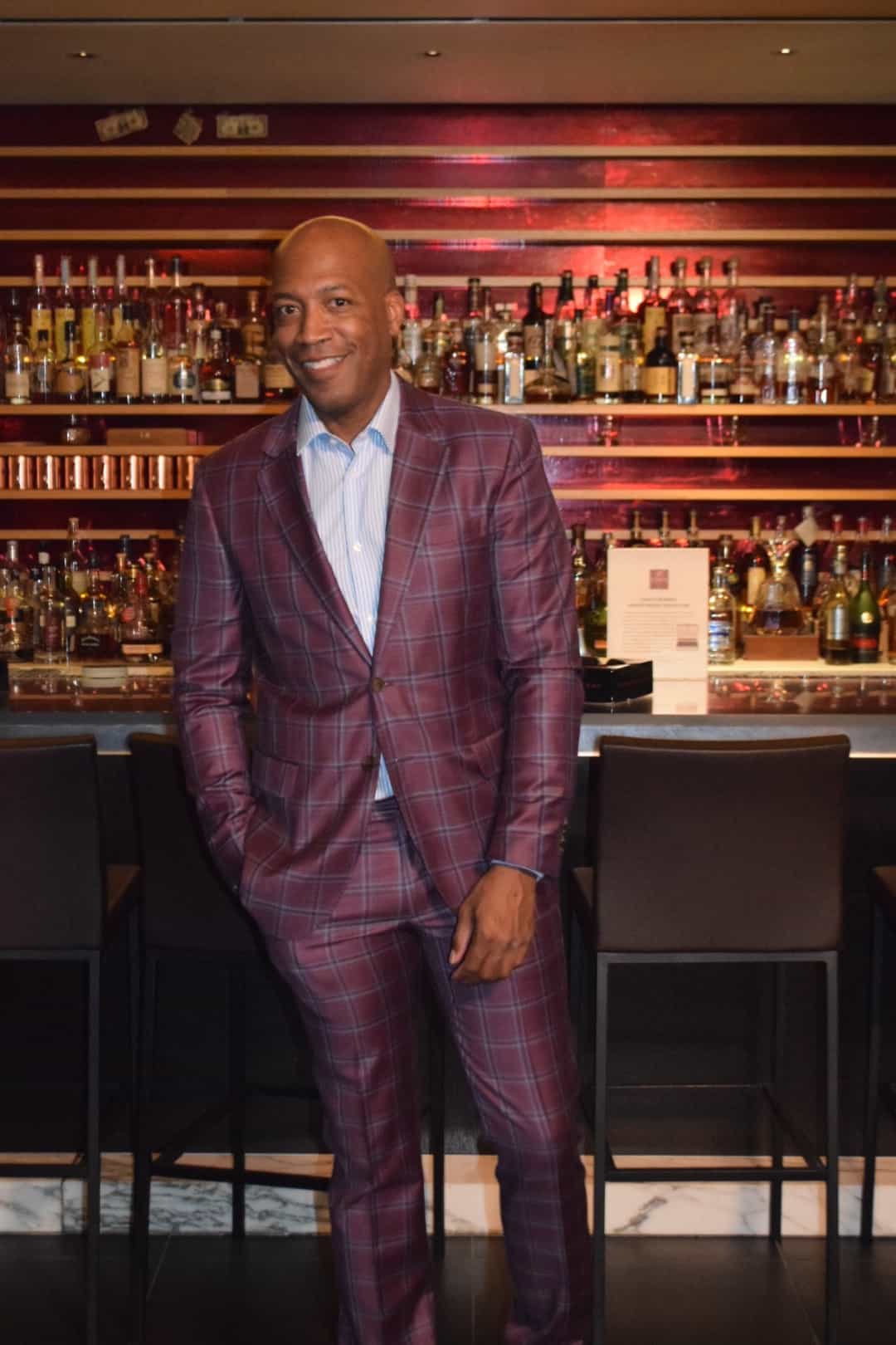 Barnette Holston wearing plaid wine color suit and striped button down