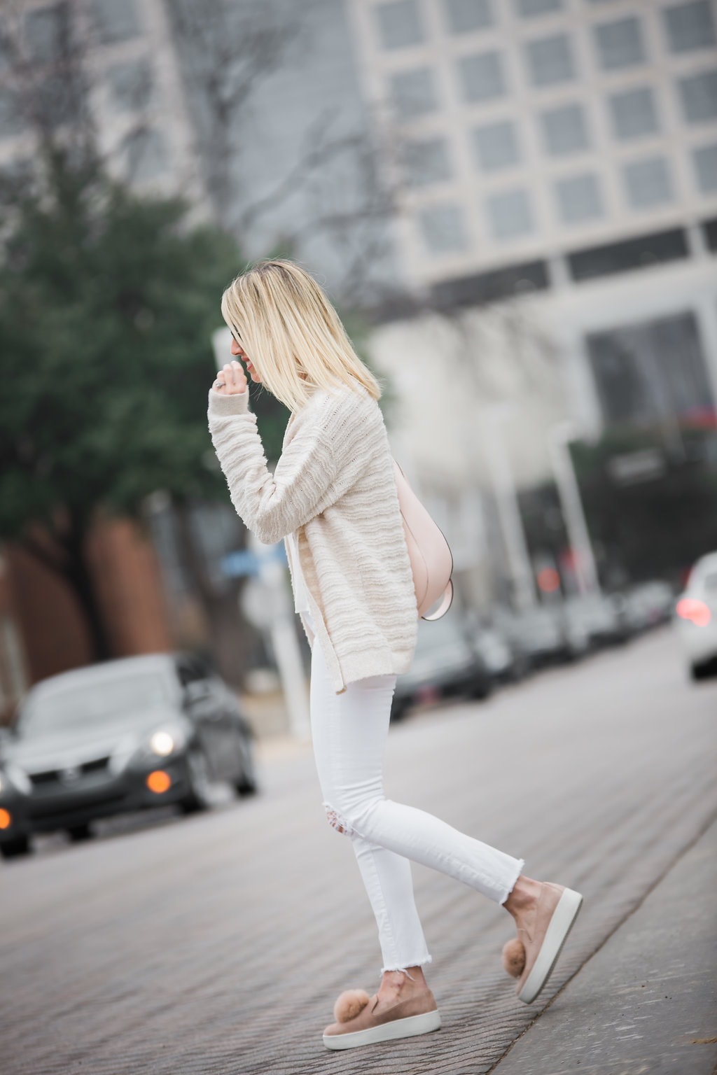 transition to spring women's outfit, white distressed jeans, beige cardigan and suede sneakers with pink bag